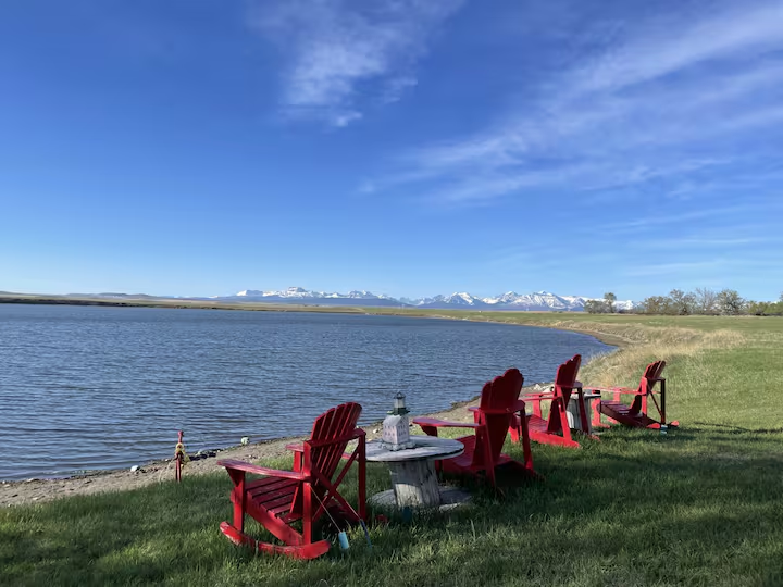 Red Adirondack chairs by the lake